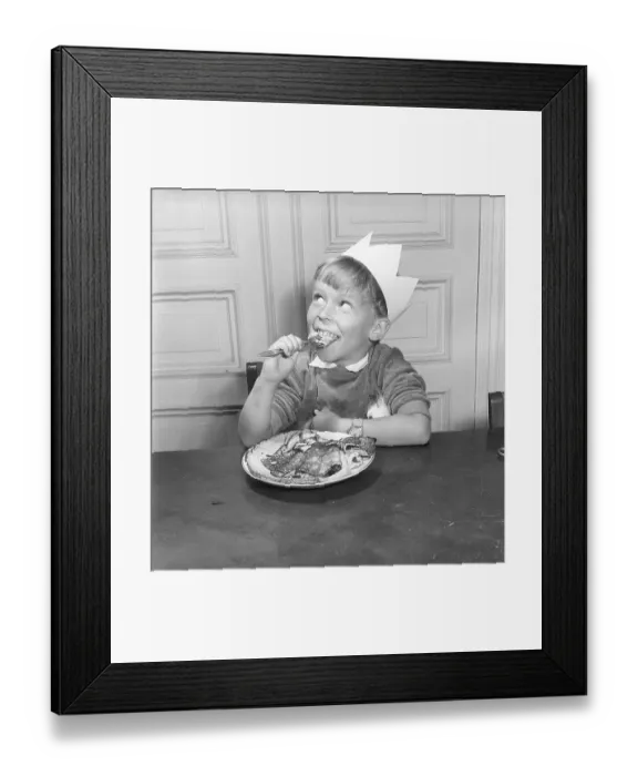 Framed Print : Boy in the 1950s. Smiling when sitting in front of a plate with pancakes and one on the fork Framed Print : Boy in the 1950s. Smiling when sitting in front of a plate with pancakes and one on the fork
