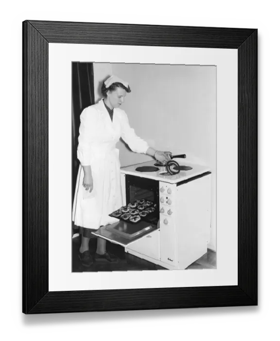 Framed Print : In the kitchen in the 1950s. A young woman in the kitchen at the brand new Kockums electric cooker