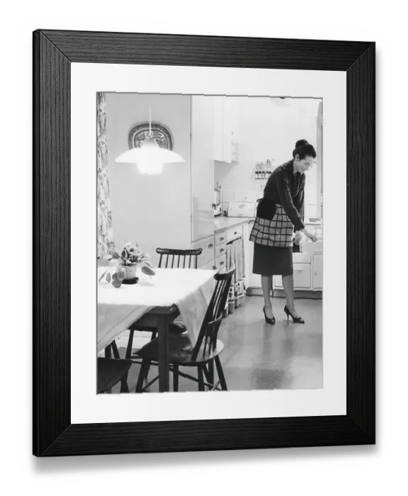 Framed Print : In the kitchen 1960s. Interior of a kitchen and a women taking something from a kitchen drawer Framed Print : In the kitchen 1960s. Interior of a kitchen and a women taking something from a kitchen drawer