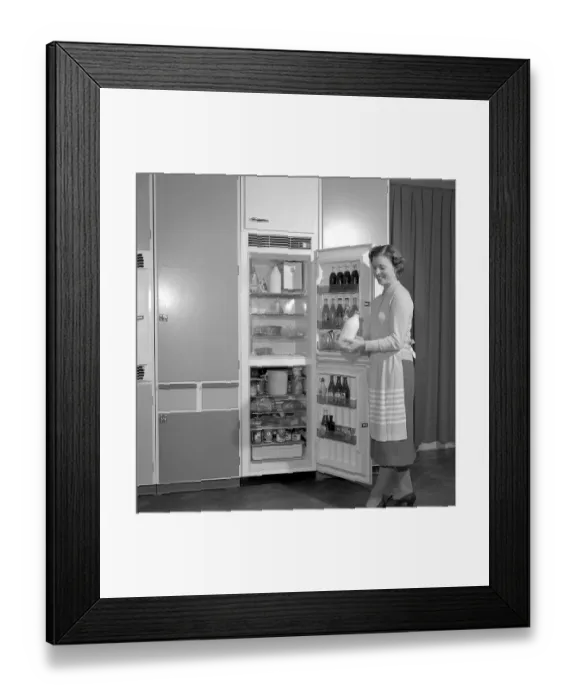 Framed Print : In the kitchen 1960s. A woman in her kitchen with the door open to the the refrigerator Framed Print : In the kitchen 1960s. A woman in her kitchen with the door open to the the refrigerator