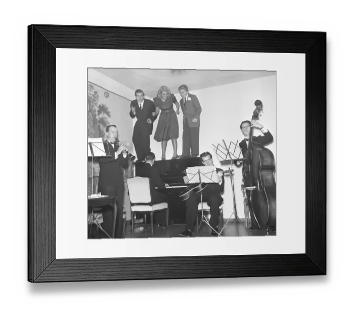 Framed Print : In the 1940s. A band with four musicians are playing while three people are standing on the piano, visibly moving to the swing music. Sweden 1943. Kristoffersson ref E23-2