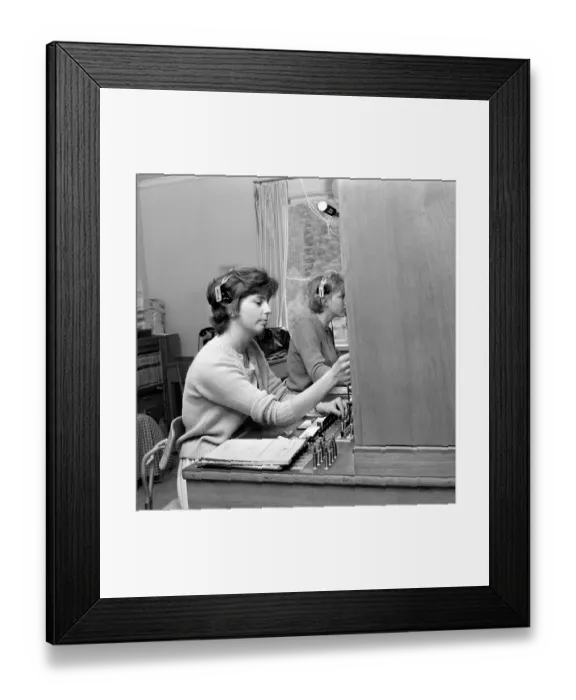 Framed Print : Telephony in the 1960s. Woman working at a telephone switchboard as it's operator