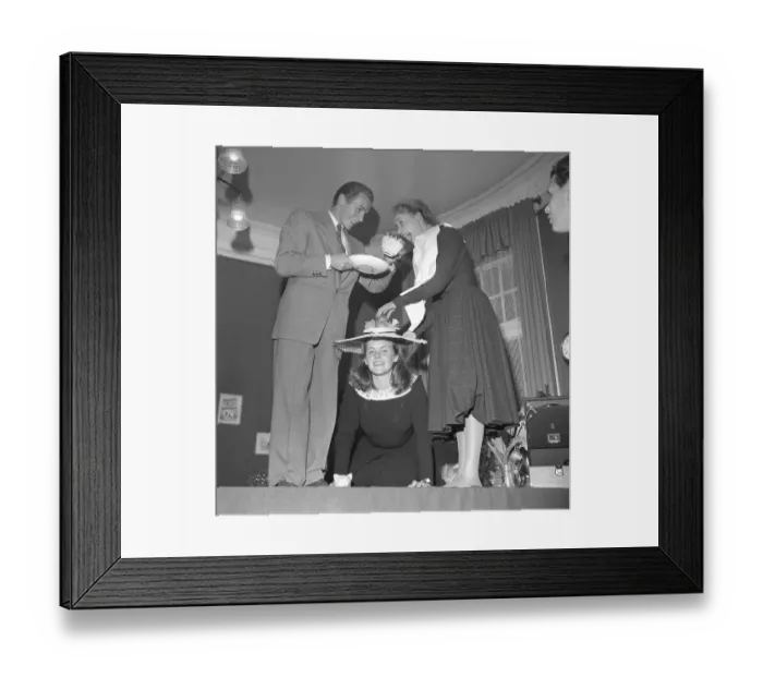 Framed Print : Fun in the 1940s. A man and woman with a large tea cup above a women on her knees
