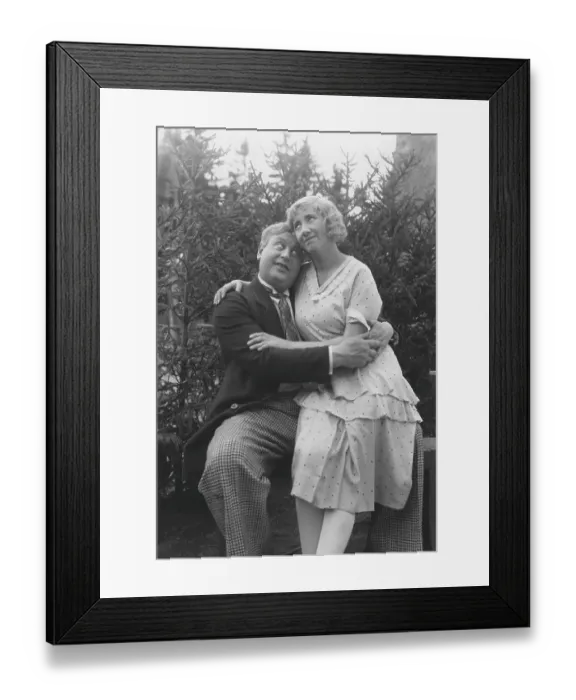 Framed Print : Love in the 1930s. A couple and where she sits on his lap and they are hugging each other tenderly