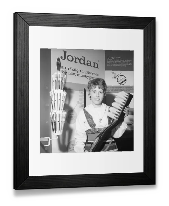 Framed Print : A young woman from the company Jordan is standing in their booth at an exhibition
