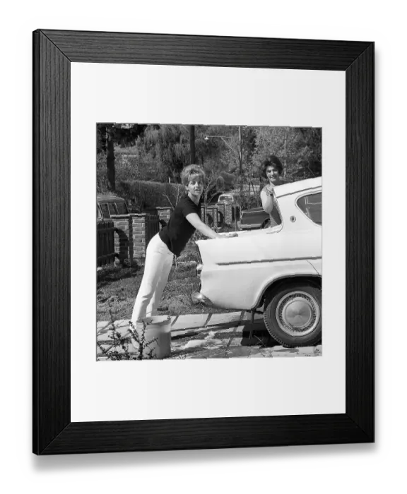 Framed Print : In the 1960s. Actress singer Lill-Babs washing her car, a Ford Anglia. her mother to the right. Sweden 1964