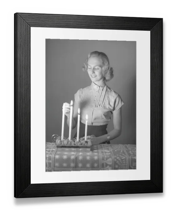 Framed Print : Christmas in the 1950s. Margit Sjoedin is lighting the candles at christmas