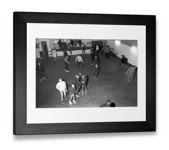Framed Print : Roller skate fun in the 1960s. Interior of a roller disco with people roller skating. Roller skating began to trend at this time and throughout the 1970s when roller skating was associated with disco music and roller discos