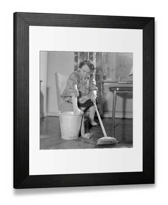Framed Print : Cleaning the floor back then. A woman looks very tired and worn out when sitting on a chair