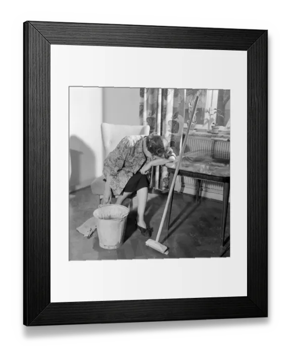 Framed Print : Cleaning the floor back then. A woman looks very tired and worn out when sitting on a chair