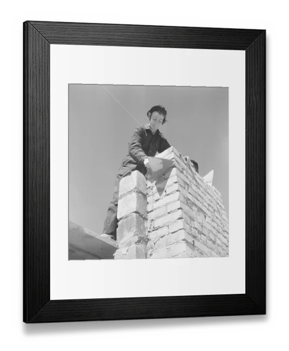 Framed Print : In the 1950s. Women construction worker is laying bricks on a building site Framed Print : In the 1950s. Women construction worker is laying bricks on a building site