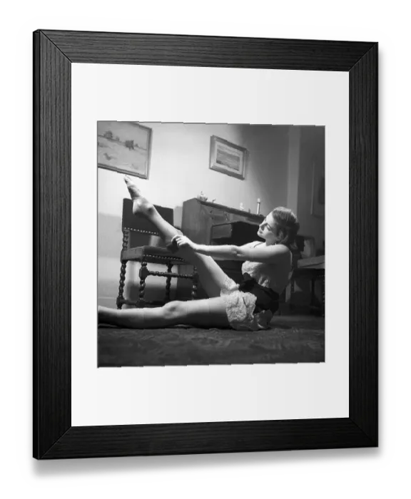 Framed Print : Nylon stockings in the 1940s. A young woman is getting dressed in the moring Framed Print : Nylon stockings in the 1940s. A young woman is getting dressed in the moring