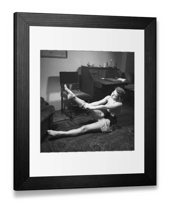 Framed Print : Nylon stockings in the 1940s. A young woman is getting dressed in the moring