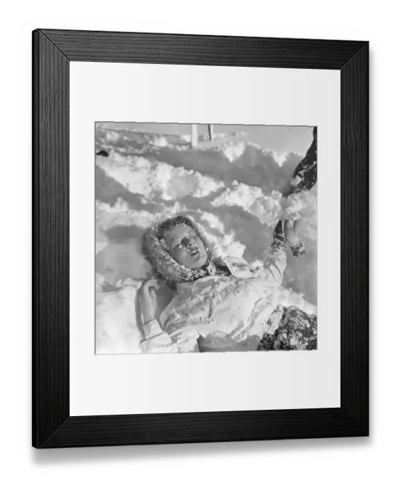 Framed Print : Winter in the 1940s. A young woman is lying in the snow