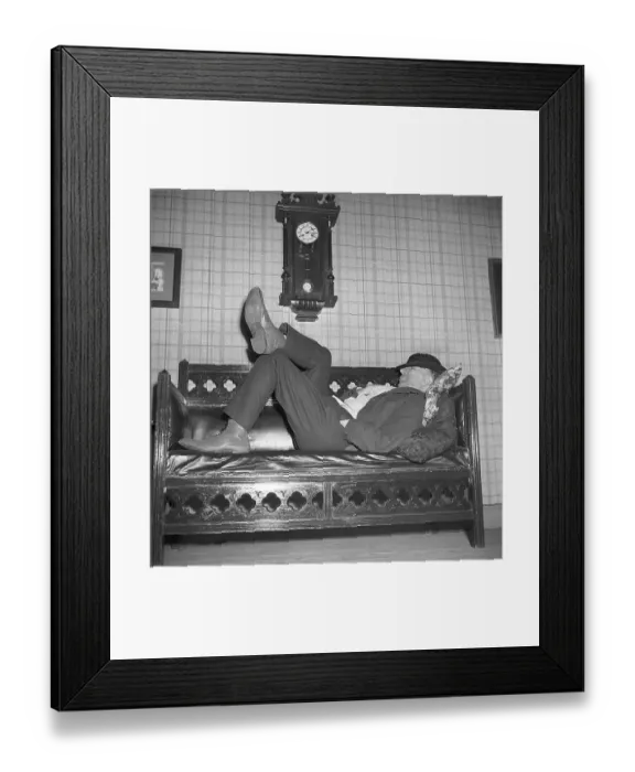 Framed Print : Having a nap in the 1940s. A tired man is lying on the sofa having a nap