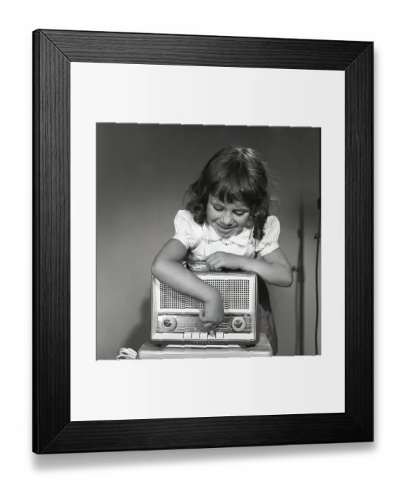 Framed Print : In the 1950s. A girl with a Philips radio set
