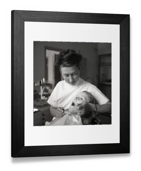 Framed Print : At the dentist in the 1940s. A boy is being examined and treated by a dentist