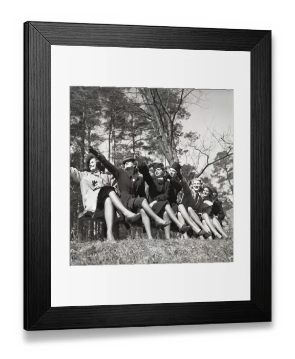 Framed Print : In the 1940s. A group of young people sitting together all points in one direction with their arms as if they want to