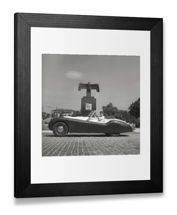 Framed Print : Driving in the 1950s. A young woman in an open convertible Jaguar XK120