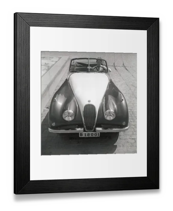 Framed Print : Driving in the 1950s. A young woman in an open convertible Jaguar XK120