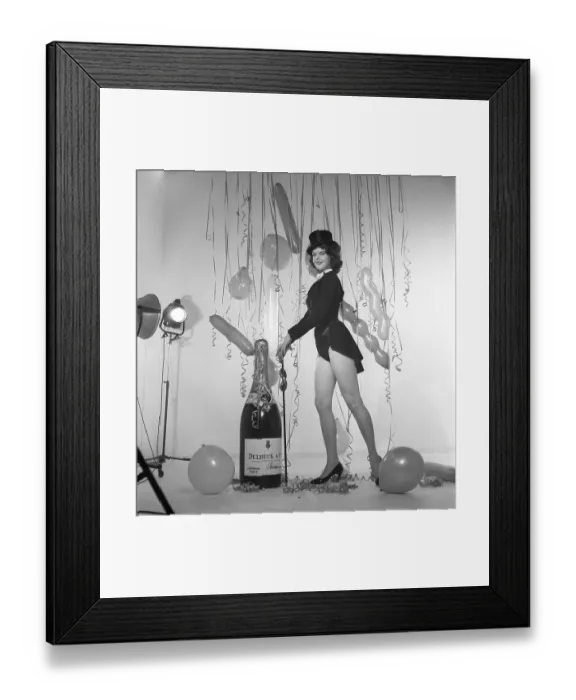 Framed Print : Champagne in the 1950s. A young woman in a scene that clearly is meant to suggest something to celebrate