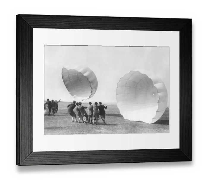 Framed Print : Parachute training in the 1930s. A school for parachuters to be are training and getting to know how a parachute works. They try their parachute and hold them against the wind. Germany 1930s