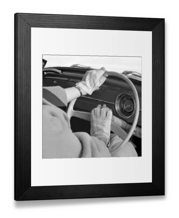 Framed Print : Driving in the 1960s. A woman demonstrates a new pair of gloves designed to be used when driving