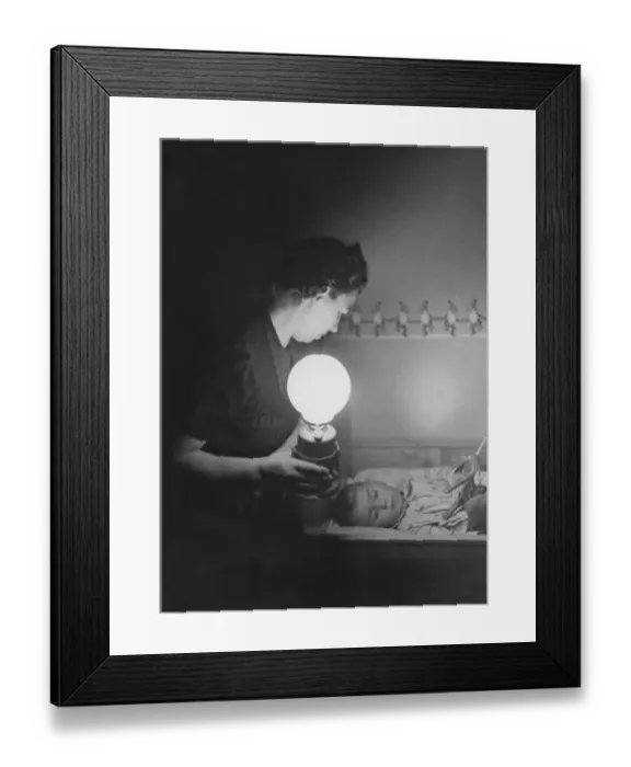 Framed Print : In the 1940s. An mother is in a room where her child is lying in a bed and sleeping