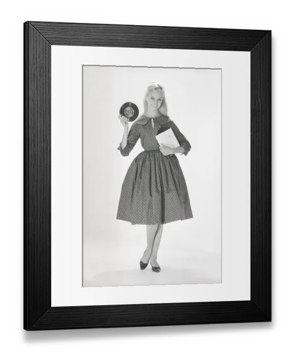 Framed Print : 1950s fashion. A young woman in a typical 1950s dress