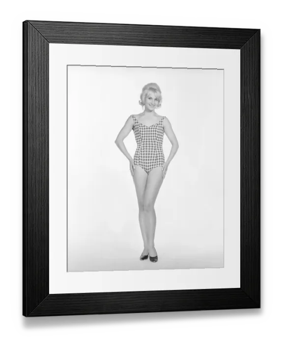 Framed Print : 1960s bikini fashion. A blonde girl in a photographers studio in a typical 1960s bathing suit