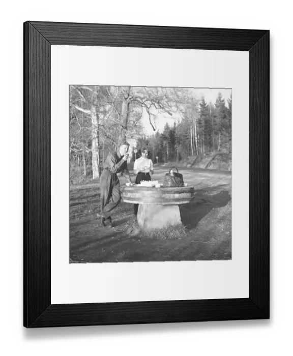 Framed Print : Lifestyle in the 1950s. A young couple has stopped to have a coffee and a sandwich by the roadside. An old millstone makes a good table for the picnic. Photo Kristoffersson Ref BF76-4. Sweden 1952