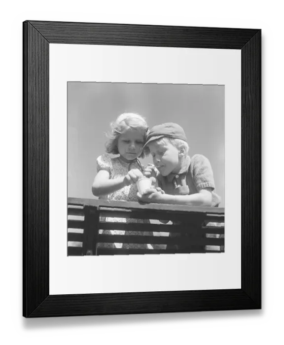 Framed Print : Summer in the 1950s. Two children are sharing one icecream Framed Print : Summer in the 1950s. Two children are sharing one icecream