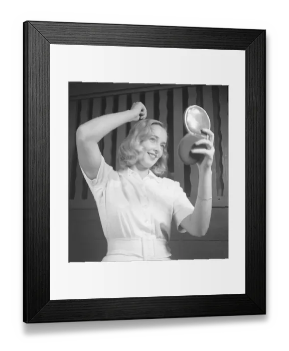Framed Print : Woman fixing her hair in the 1940s Framed Print : Woman fixing her hair in the 1940s