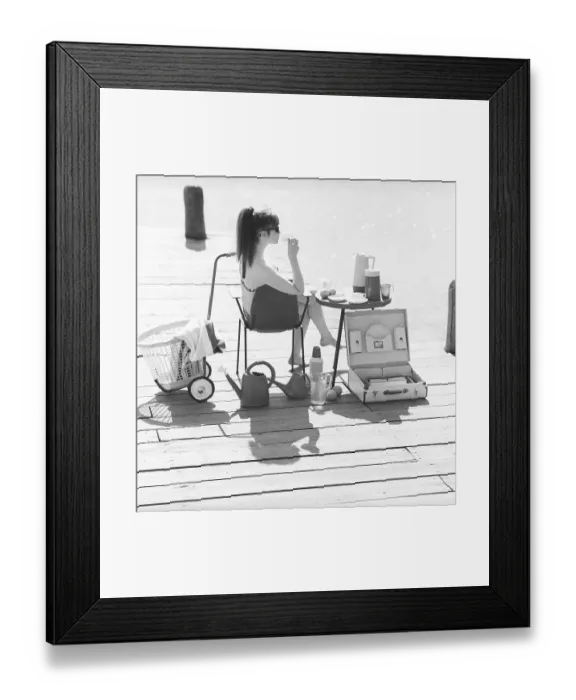 Framed Print : 1960s lifestyle. A young woman sitting in the sun wearing a bikini
