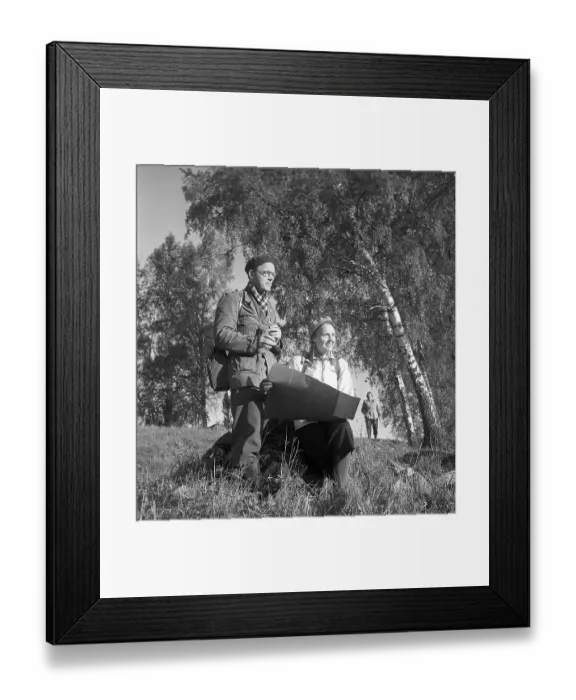Framed Print : 1940s outdoor life. A couple is out in the nature and is interested in plants and flowers Framed Print : 1940s outdoor life. A couple is out in the nature and is interested in plants and flowers