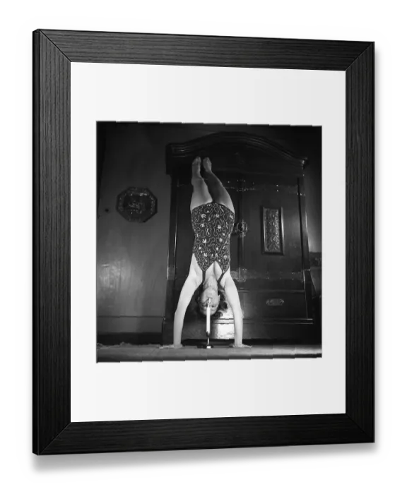 Framed Print : Woman of the 1940s. A woman is seen practising gymnastics while lighting her cigarette on a candle
