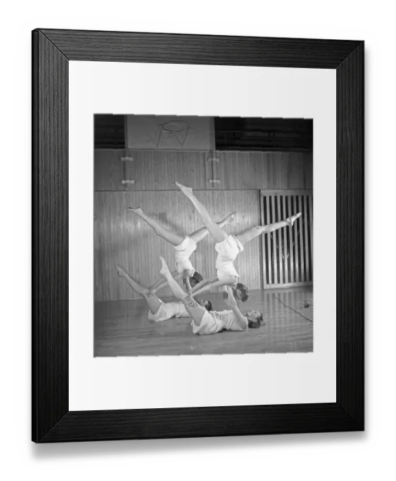 Framed Print : Gymnastics in the 1940s. Four young female gymnasts are practicing together and doing the same movement Framed Print : Gymnastics in the 1940s. Four young female gymnasts are practicing together and doing the same movement