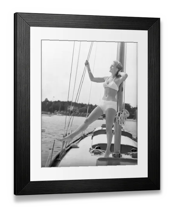 Framed Print : 1940s bikinifashion. A swedish young woman in a white bikini on a sailing boat on a summer's day