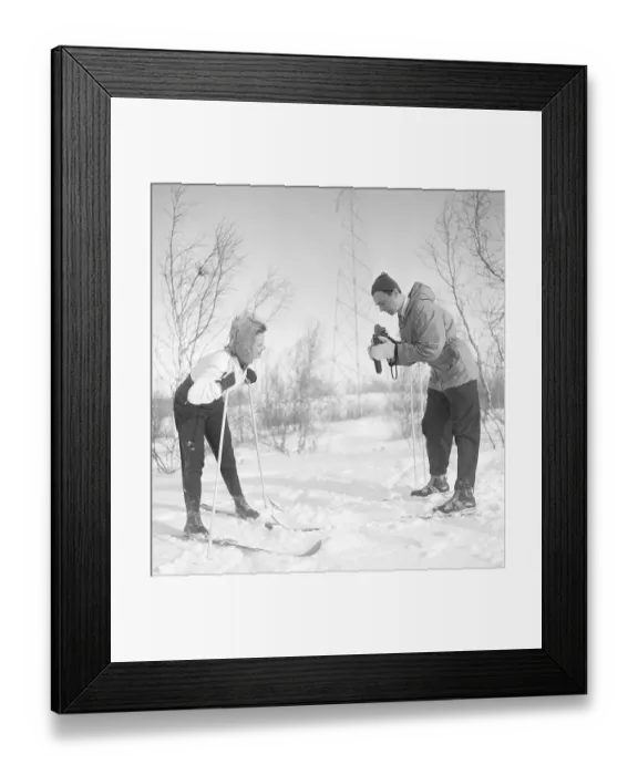 Framed Print : Winter in the 1940s. Actor Nils Kihlberg, 1915-1965 is pictured here with his wife Ann-Britt. He is taking pictures of her on their winter vacation. They are both wearing winter clothes and skis. The camera is a Rolleiflex by german company Rollei Framed Print : Winter in the 1940s. Actor Nils Kihlberg, 1915-1965 is pictured here with his wife Ann-Britt. He is taking pictures of her on their winter vacation. They are both wearing winter clothes and skis. The camera is a Rolleiflex by german company Rollei