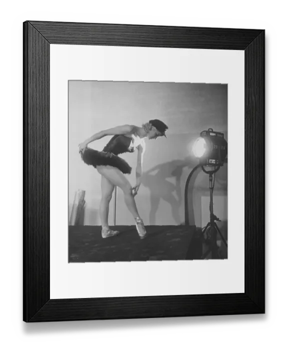 Framed Print : Ballet dancer in the 1950s. A young woman in her stage costume is standing with a spotlight directed at her body