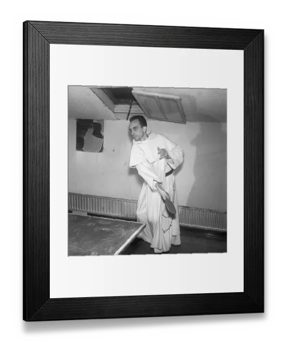 Framed Print : Monk plyaing table tennis. A monk in a white robe is playing table tennis Framed Print : Monk plyaing table tennis. A monk in a white robe is playing table tennis