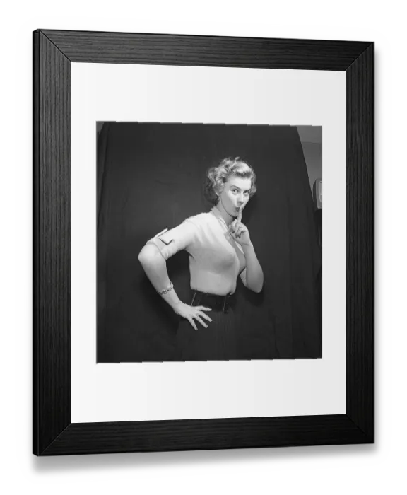 Framed Print : In the 1950s. A young blonde woman is looking into the camera