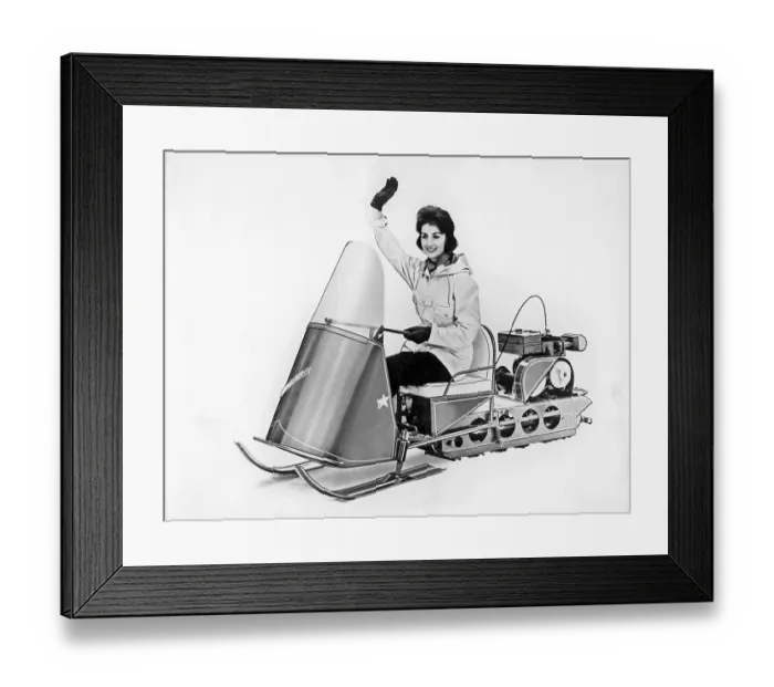 Framed Print : Snowmobile in the 1950s. The young woman is driving a snowmobile model Winter boy in the 1950s Framed Print : Snowmobile in the 1950s. The young woman is driving a snowmobile model Winter boy in the 1950s