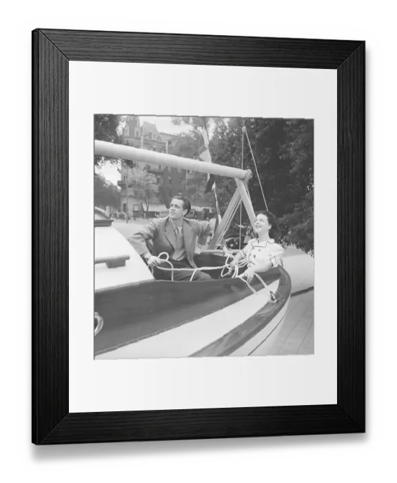 Framed Print : 1940s summer. A young couple in a sailingboat on dry land Framed Print : 1940s summer. A young couple in a sailingboat on dry land