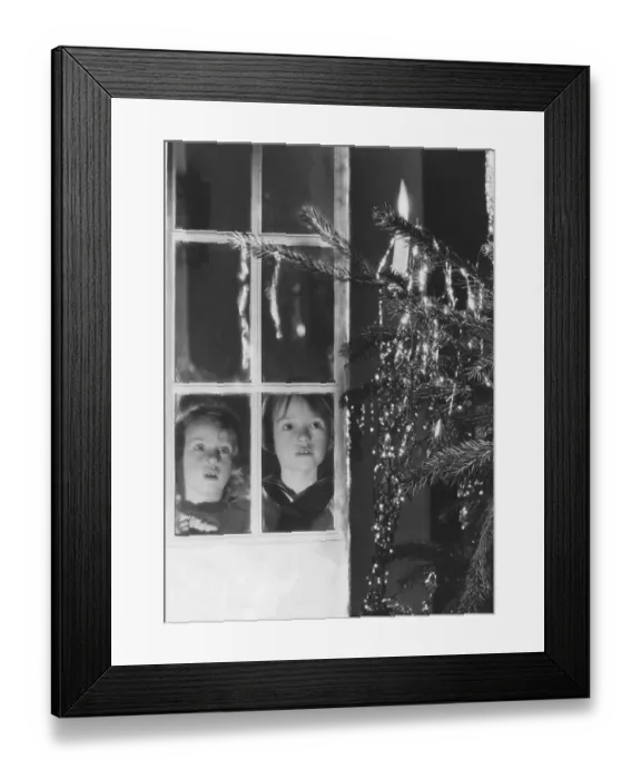 Framed Print : Christmas in the 1940s. Two children are looking at the christmas tree at christmas eve Framed Print : Christmas in the 1940s. Two children are looking at the christmas tree at christmas eve
