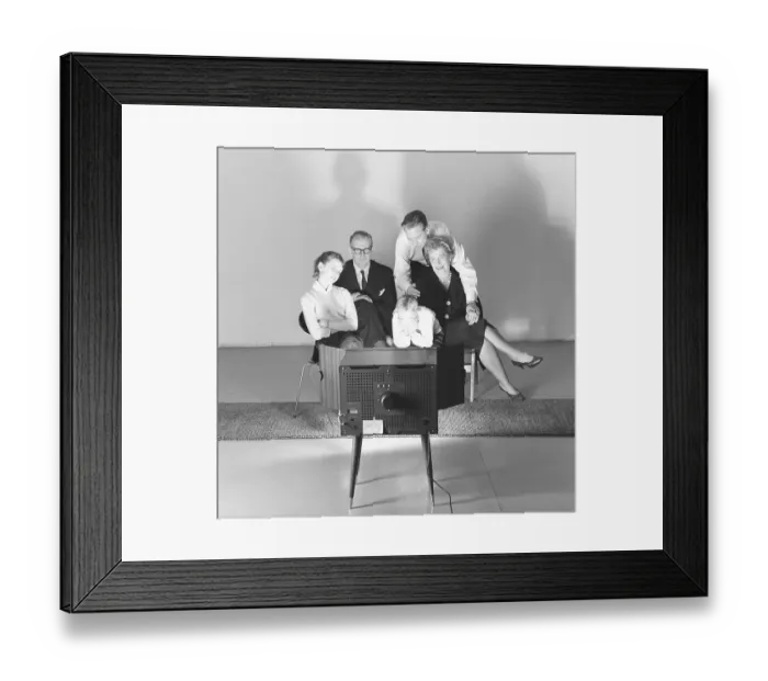 Framed Print : Television in the 1950s. Family in front of a television set and fascinated by the new television medium in March 1959