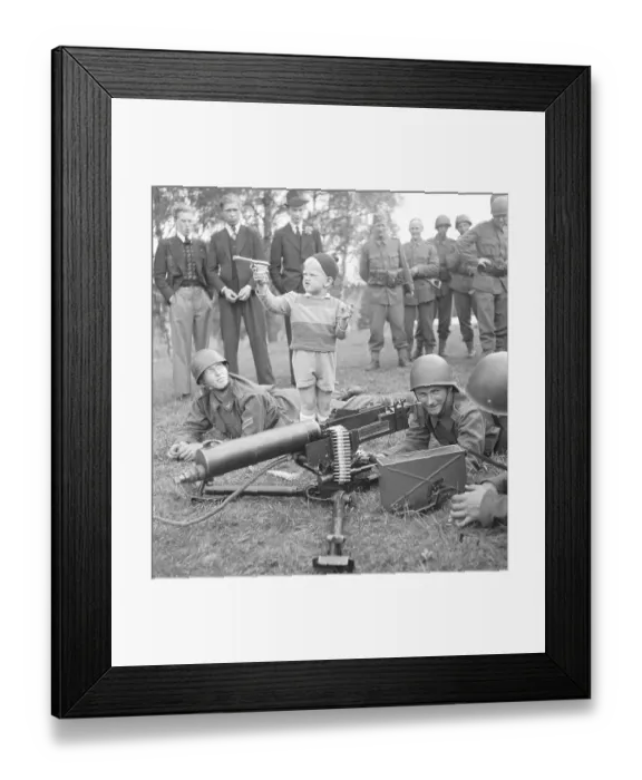 Framed Print : Swedish Soldiers on Regiments day. The new Heavy machine gun is being displayed and showed to the public visiting the grounds. A Young boy has brought his own toy revolver and is joininig in the shooting. Sweden 1942. Kristoffersson ref C17-2