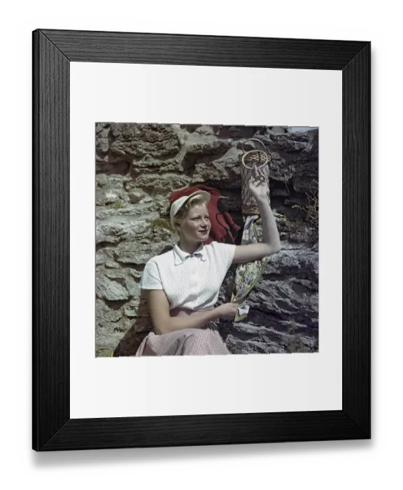Framed Print : 1950s fashion. A young woman is wearing a white blouse and a matching hat