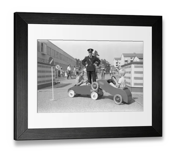 Framed Print : 1950s policeman. Two boys are playing in their pedal cars