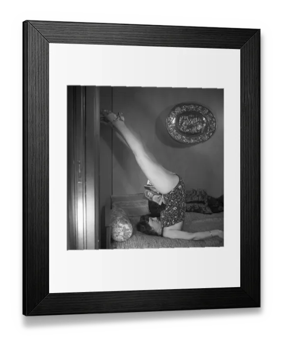 Framed Print : Woman of the 1940s. A woman is seen practising gymnastics while reading a magazine Framed Print : Woman of the 1940s. A woman is seen practising gymnastics while reading a magazine